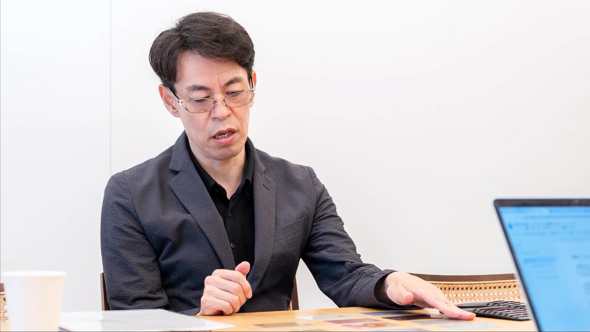 写真。製作陣がクレジットカードを並べて資料とともに検証している様子