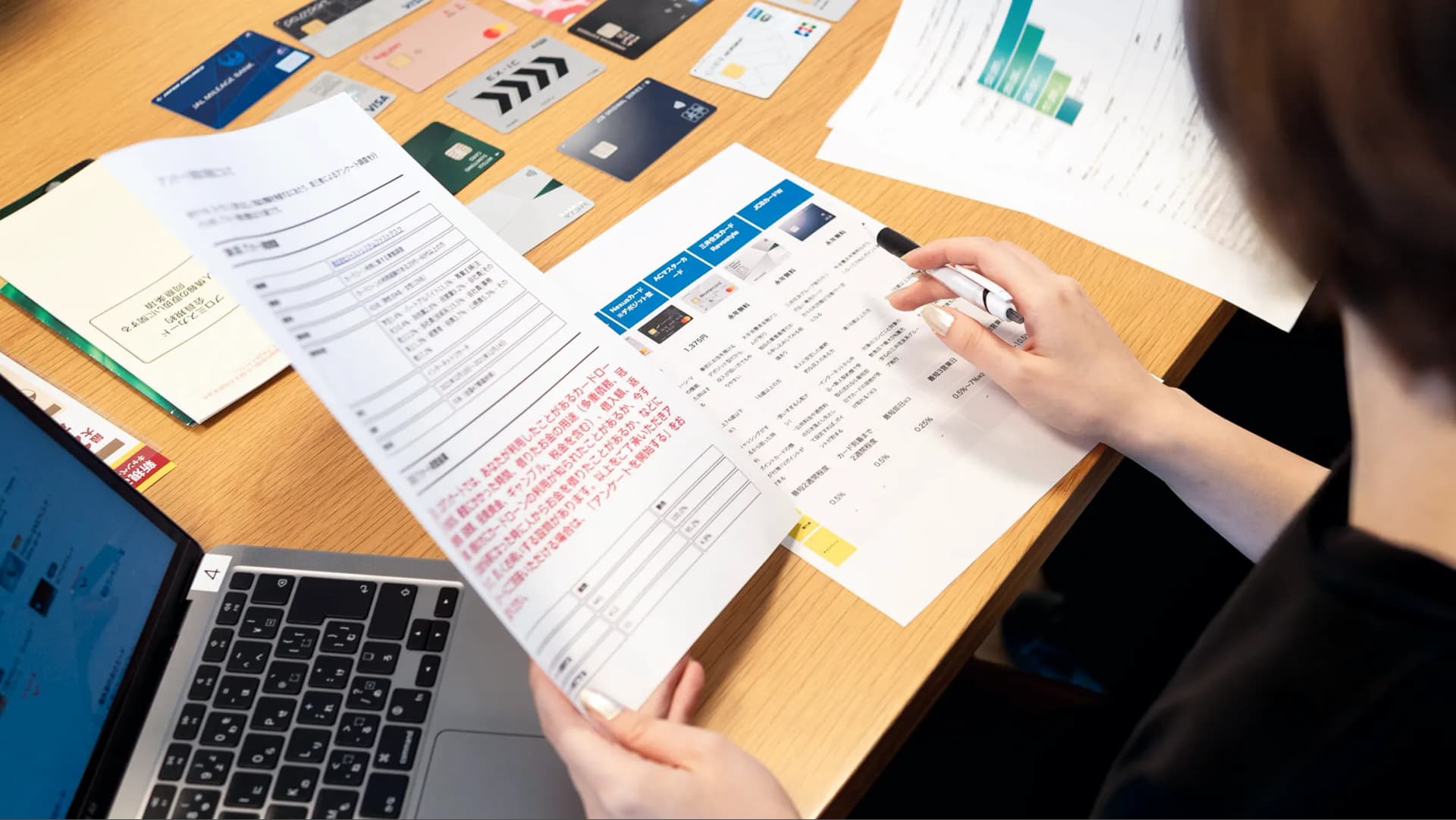 写真。製作陣がクレジットカードを並べて資料とともに検証している様子