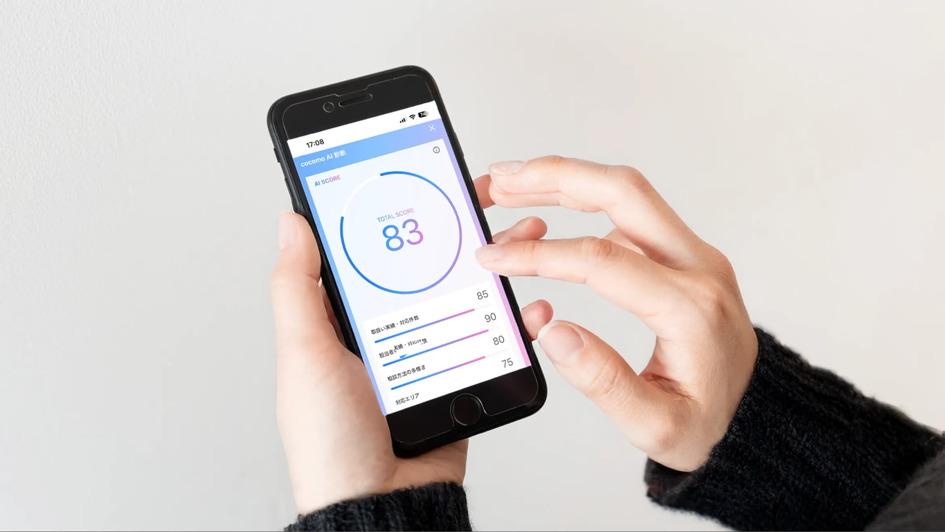 写真。iPhoneの画面にCocomoAI診断の結果が表示されている画面を操作している様子